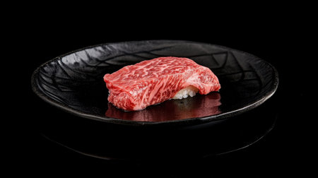 An elegant presentation of wagyu sushi served on a sleek black plate. This gourmet dish highlights the luxurious texture and flavor of premium beef. Perfect for fine dining.の素材