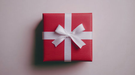 A clean and elegant red gift box with a white ribbon, placed against a white background, perfect for holiday gift-giving stock photos.の素材
