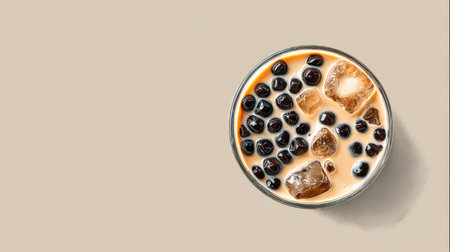 A delightful and refreshing sweet beverage featuring rich tapioca pearls and ice cubes, served in a transparent glass on a neutral background, perfect for summer enjoyment.の素材