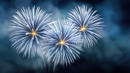 This stunning image showcases blue and white fireworks bursting in the night sky, perfect for capturing the essence of celebration and festive joy in any project.の素材