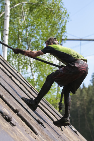 Muddy obstacle race runner in action. Mud run.の写真素材