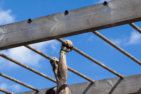 Muddy obstacle race runner in action. Mud run.