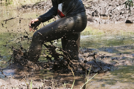 Muddy obstacle race runner in action. Mud run.の写真素材