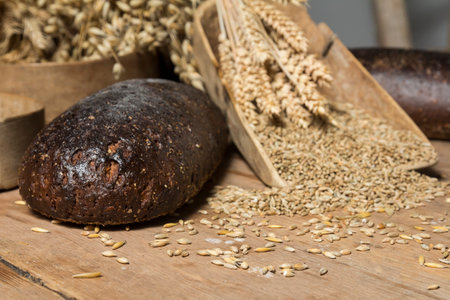 Bread Background. Brown Whole Grain Loaves Composition On Rustic Wood With Wheat Ears Scatteredの写真素材