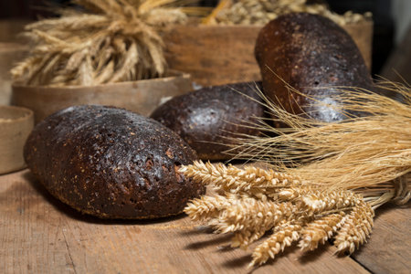 Bread Background. Brown Whole Grain Loaves Composition On Rustic Wood With Wheat Ears Scattered