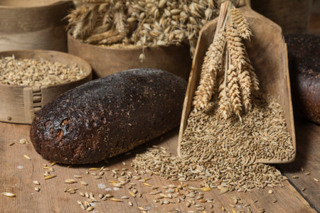 Bread Background. Brown Whole Grain Loaves Composition On Rustic Wood With Wheat Ears Scatteredの写真素材