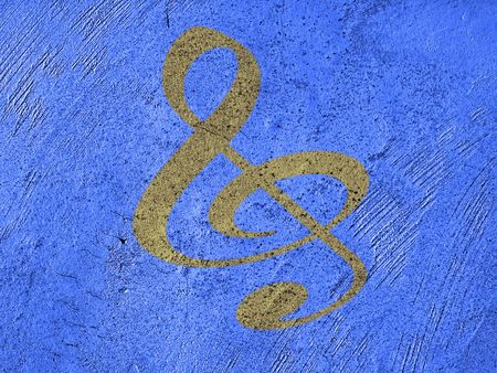 golden music note on a grunge blue wall     の写真素材