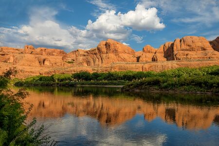 Colorado River in the evening with mountains in the background that are reflected in the water....