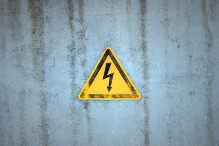 Electricity warning sign on a weathered backgroundの写真素材