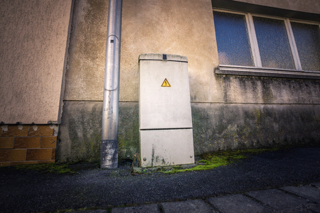Power supply box from a low angle beside some windows の写真素材
