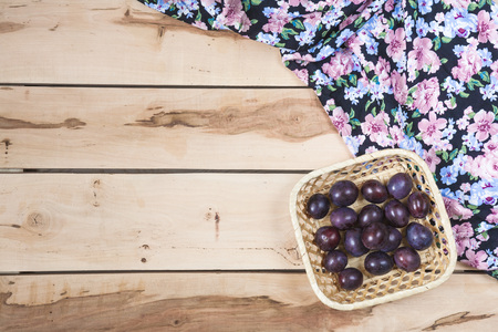 Fresh seasonal plums in a little basket with colorful napkinの写真素材