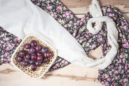 Fresh seasonal plums in a little basket with colorful napkinの写真素材