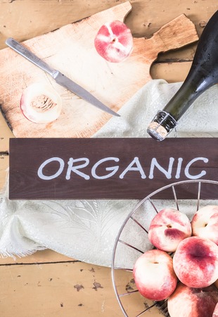 Peach vine and fresh organic peaches on the wooden backgroundの写真素材