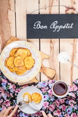 Homemade pumpkin pancakes on the wooden table with sour creamの写真素材