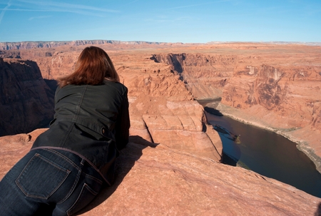 Woman leaning on rock looking at a view, Horseshoe Bend, Glen Canyon National Recreation Area, Arizona-Utah, USAのeditorial素材