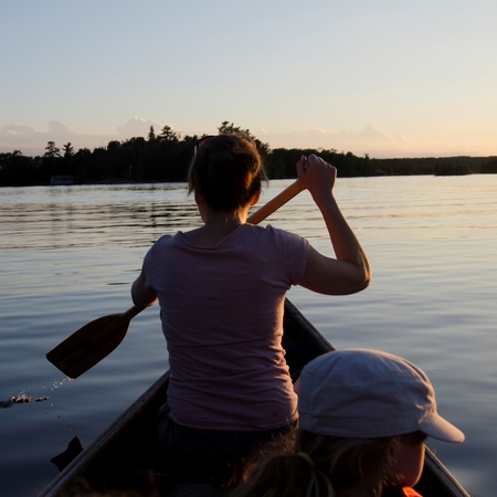 Woman rowing a boat with her daughter, Lake of the Woods, Ontario, Canadaの写真素材