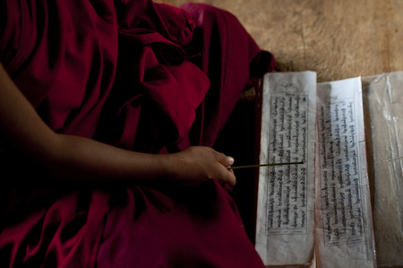 Monk reading a prayer book at Chimi Lhakhang, Punakha District, Bhutanの写真素材