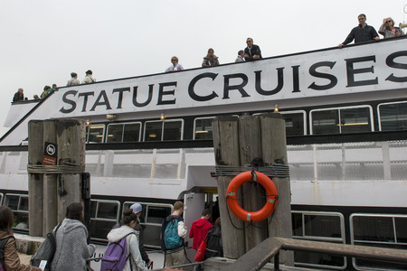 Tourists boarding a ship to the Statue of Liberty, Liberty Island, New York Harbor, Manhattan, New York City, New York State, USAのeditorial素材
