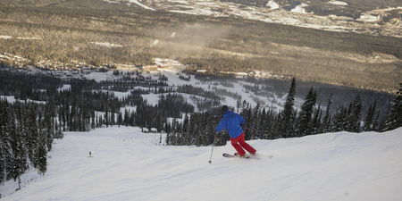 Tourist skiing in valley,  Kicking Horse Mountain Resort, Golden, British Columbia, Canadaの写真素材