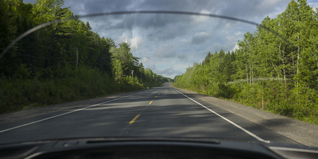 Road amidst trees seen through car windscreen, Doaktown, New Brunswick, Canadaの写真素材