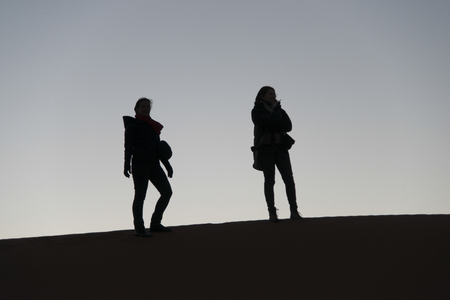 Women standing on Erg Chegaga Dunes in Sahara Desert, Souss-Massa-Draa, Moroccoの写真素材