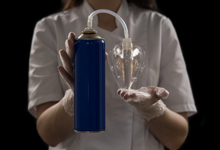 Unrecognizable female doctor holding can with oxygen and breathing through the mask
