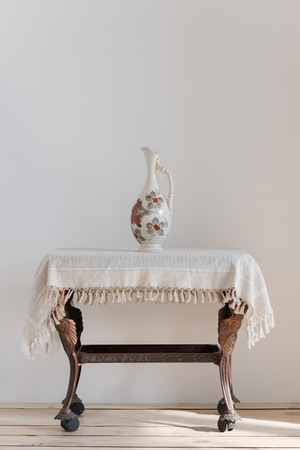 Vintage table and vase in sunlightの写真素材