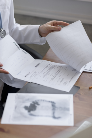 Doctor working with test results of his patient at his office