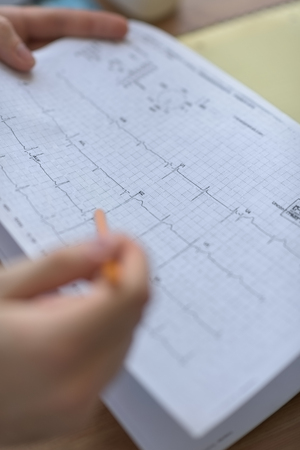 Confident practitioner consulting woman in hospital. Reading ecg resultsの写真素材