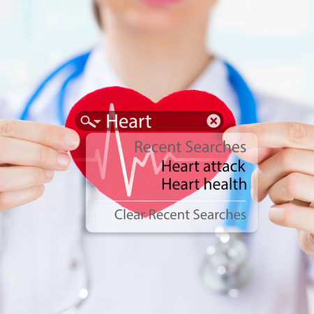 Doctor holding heart and heartbeat symbol with search engine and heart attack signの写真素材
