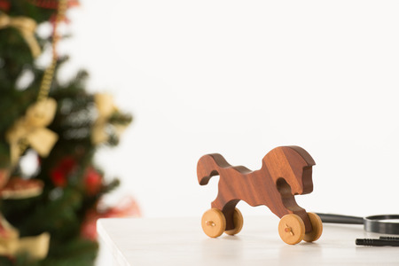 Vintage Wooden Horse on Santa's work table, Christmas Tree on backgroundの写真素材