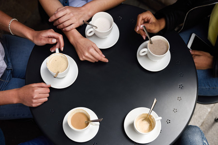Top view of hands with coffee cups on table in a urban cafe.の写真素材