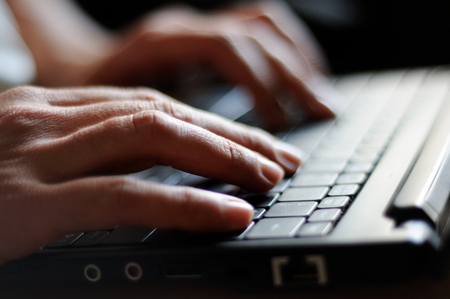 woman's hands typing on a laptopの写真素材