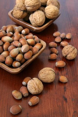 Hazelnuts and walnuts in wooden bowlsの写真素材