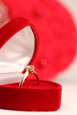 Golden engagement ring in a heart shaped boxの写真素材