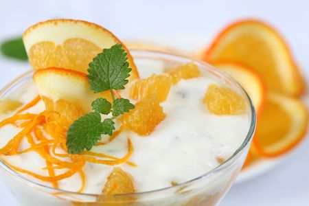 Yogurt dessert with oranges on white background. Shallow DOFの写真素材