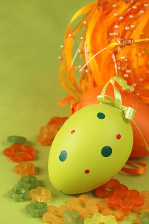 Green and orange Easter egg with little glass flowers and ribbonの写真素材