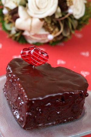 Heart shaped chocolate cake with heart decoration and bouquetの写真素材