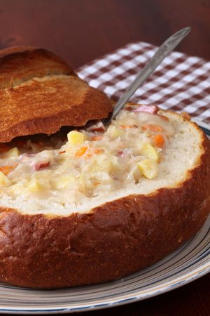 Traditional Czech cabbage soup made from sauerkraut with potato, carrot and meat sausage, served in a bread bowlの写真素材