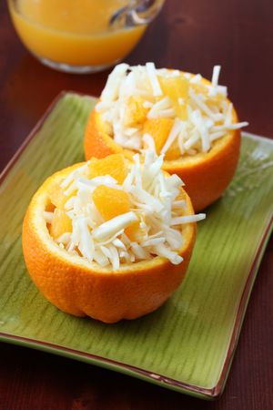 Salad with cabbage and orange served in an orange bowlの写真素材