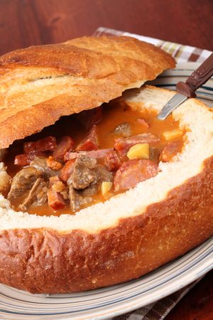 Goulash soup with beef, potato and meat sausage, served in a bread bowlの写真素材