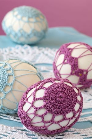 Easter eggs with beautiful purple and blue crochet decorationの写真素材
