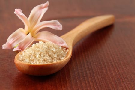 Cane sugar in a wooden spoon with little hyacinth flowerの写真素材