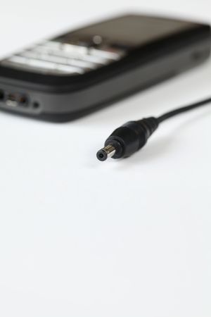 Cell phone charger and cell phone on white background. Plenty of copy spaceの写真素材