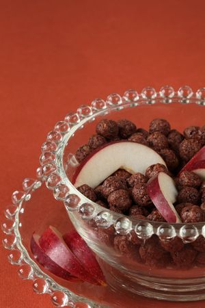 Chocolate cereals with slices of red appleの写真素材