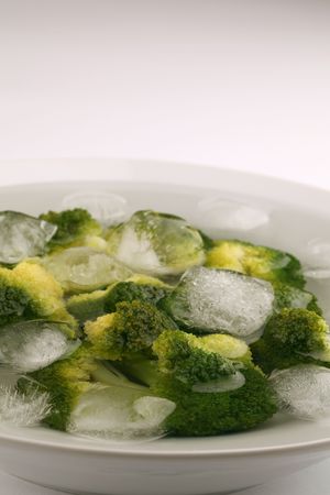 Boiled broccoli in cold water with ice cubes to preserve the bright green colorの写真素材