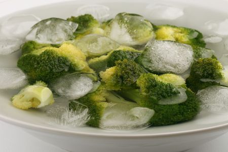 Boiled broccoli in cold water with ice cubes to preserve the bright green colorの写真素材