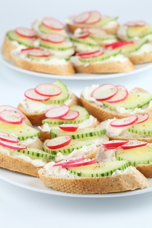 Appetizers with cream cheese, radish and cucumber seasoned with freshly ground pepperの写真素材