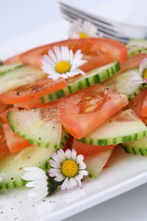 Spring salad with vegetables and daisiesの写真素材