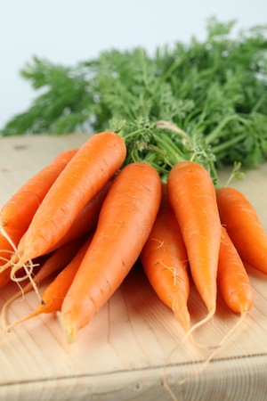 Bunch of fresh organic carrots on cutting boardの写真素材